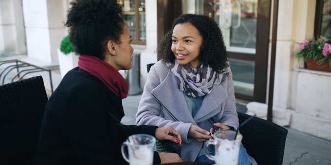 betekenis enerverend: twee vriendinnen in gesprek op een terras